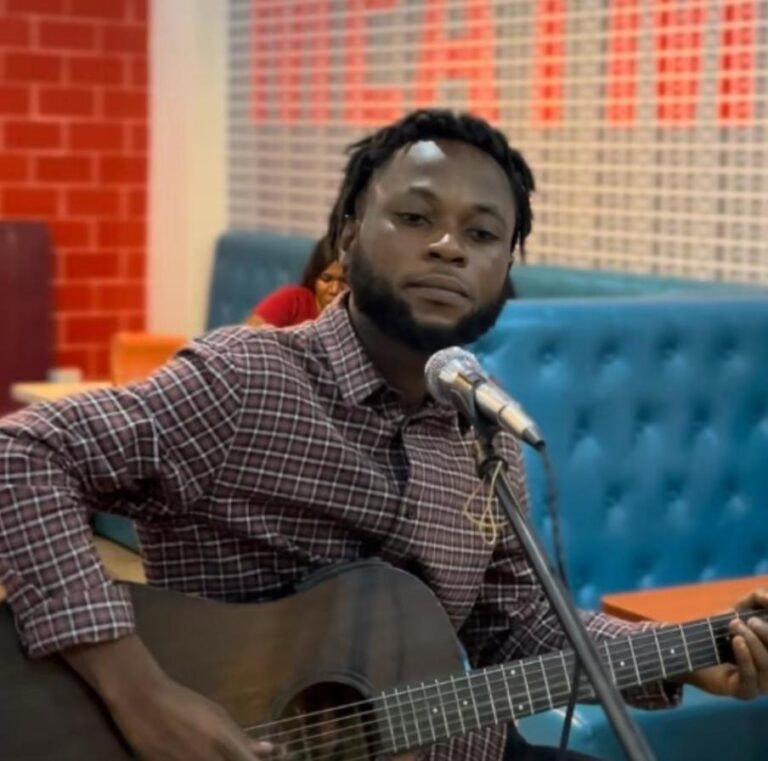 Osei playing guitar at a microphone during a Sound and Color Africa session